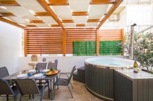 帕洛港Al Mare的庭院设有热水浴池、桌子和椅子。