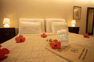 皮帕Beija Flor Exclusive Hotel & Spa的一间卧室,床上有红色的鲜花