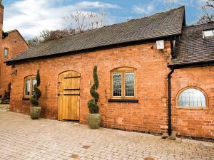 DunstallGrooms Cottage - E5398的砖砌的建筑,有门,有仙人掌