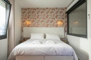 佩里格Le Maleville - Balnéo & Ascenseur的卧室配有白色的床和2条毛巾