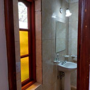 卡法亚特Hostal killari的一间带水槽和镜子的浴室以及窗户。