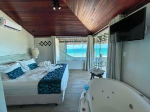 嘎林海斯港Pousada Maracabana Spa的一间带浴缸、床和浴缸的卧室