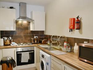布莱奈费斯蒂尼奥格Llwyn Rhedyn的厨房配有白色橱柜和炉灶烤箱。