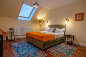 德瓦Vila Missy的一间卧室配有一张带橙色毯子和窗户的床。