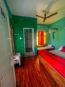 索拉哈Tiger Corner Inn Homestay的一间拥有绿色墙壁的卧室和一张铺有红色床单的床
