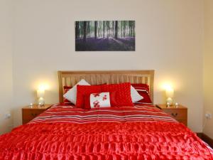 卡马森戴尔瑞乡村别墅的一间卧室配有红色的床和红色枕头