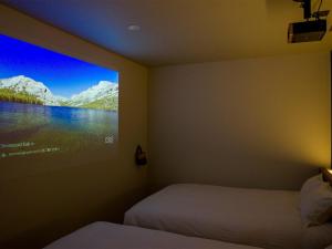 富士河口湖Rakuten STAY Fuji Kawaguchiko Station - Japanese Modern Villa Mt Fuji View 107的一间卧室设有两张床,墙上配有电视。