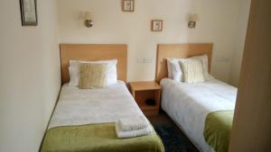 柯库布里斯达尔酒店的配有衬衫的酒店客房内的两张床