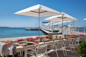 戛纳雄伟戛纳巴里耶尔酒店的海滩上带桌椅的餐厅