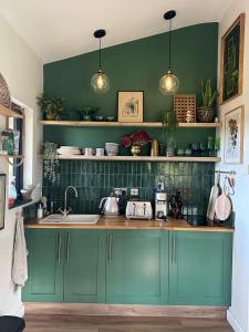 约克Meadows Lodge的厨房设有蓝色橱柜和绿色的墙壁