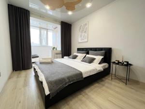 巴甫洛达尔Апартаменты LUX +的一间卧室设有一张大床和一个窗户。