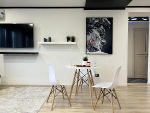 巴甫洛达尔Апартаменты LUX +的一间配备有白色桌椅的用餐室