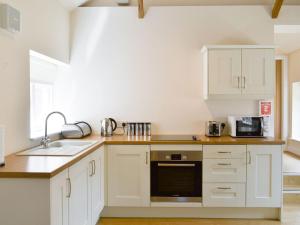 binbrookMays Mews的厨房配有白色橱柜和水槽