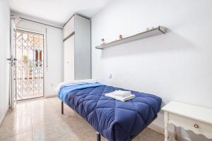 贝尼多姆Benidorm Old Town House - Casa Casco Antiguo的一间设有蓝色床和窗户的小卧室