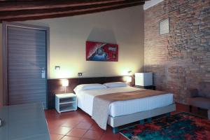 帕尔马Villa D&D的一间卧室设有一张大床和砖墙