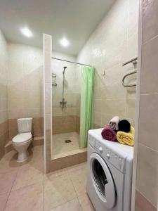 阿克套Однокомнатные апартаменты в золотом квадрате ЖК GREEN PLAZA的带淋浴的浴室内的洗衣机