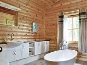 GlenfargAshknowe Log Cabin - S4590的木制浴室设有浴缸和水槽