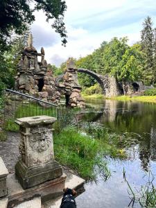 皮尔纳Das Ferienhaus mit Aussicht的一座石雕,毗邻一条有桥的河流