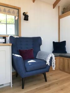 巴斯Skylark Shepherds Hut的一张蓝色椅子,位于带床的房间