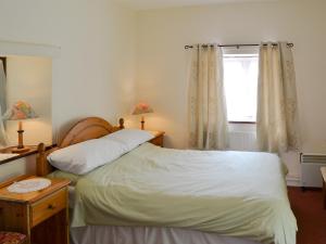 Neatishead惠里阿奇乡村别墅的一间卧室设有两张床和窗户。