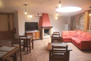 奥利特Hostal Rural 18 de Abril的客厅设有红色的沙发和壁炉