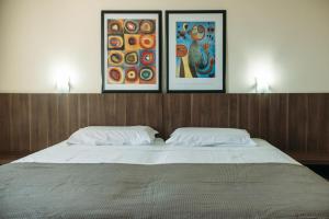 阿莱格雷特Hotel Caverá的一张带两个枕头的床,上面有三张照片