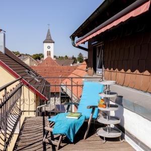 布雷滕Charmante, großzügige Ferienwohnung Villa Fleurie的一个带钟楼的阳台的桌椅