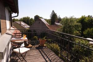 布雷滕Charmante, großzügige Ferienwohnung Villa Fleurie的阳台配有桌椅,位于甲板上
