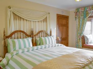 KilchenzieHazels Cottage的一间卧室配有一张带条纹枕头的大床