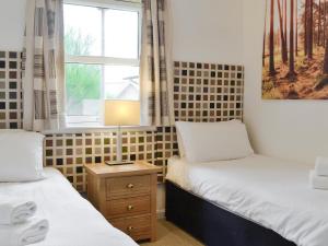 Inchmarlo32 Queens Court的带窗户的客房内设有两张单人床。