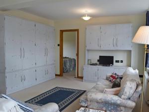 马伯斯Bracelet Cottage的客厅配有白色橱柜和沙发。