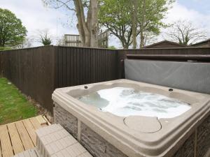 WinthorpeBarn Cottage - E5560的后院的热水浴池,带围栏