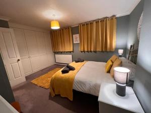 诺里奇Lovely Stylish 3 Bed House with Free Parking的一间卧室配有一张带黄色毯子的大床