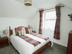 普柳Mackenzie Cottage的一间卧室设有一张床和一个窗口