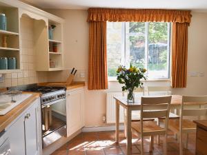 奇平卡姆登罗斯迎宾小屋的厨房配有桌子和窗户