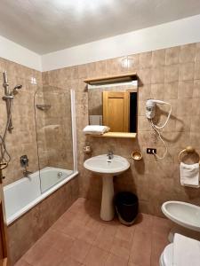 摩德纳迪-坎皮格里奥Albergo Ristorante Al Fratè da Streza的一间带水槽、淋浴和卫生间的浴室
