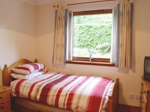 Oakley茵兹瓦尔乡村别墅的一间卧室设有一张床和一个窗口
