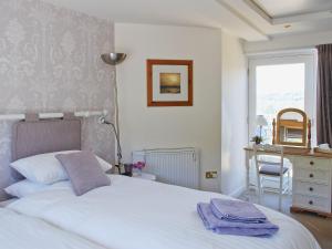 Almondbury阿波尔施恩乡村别墅的卧室配有白色的床和窗户。