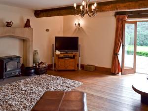 HeptonstallLee Cottage的客厅配有平面电视和壁炉。