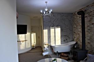 迈季代勒舍姆斯Tower of the sun的一间带白色浴缸和砖墙的浴室