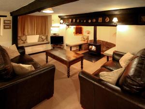 Brompton Ralph奥德维尔乡村别墅的客厅配有皮革家具和壁炉