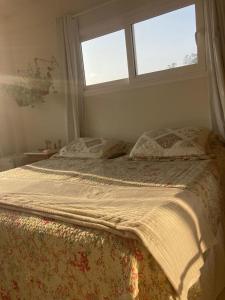 邦比尼亚斯Apartamentob301 coliving bombinhas的卧室内的一张床位,设有两个窗户