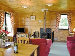 格勒尼斯拉基克顿Larch Cottage - S4428的客厅设有红色的沙发和壁炉