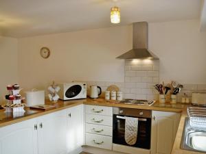 CilybebyllY Stabl-w43382的厨房配有白色橱柜和炉灶烤箱。