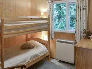 Crackington Haven切特里瓦撒乡村别墅的一间卧室设有两张双层床和一扇窗户。