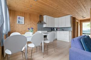 Sørreisa Fiske og Feriesenter的一间厨房,内设白色的椅子和桌子
