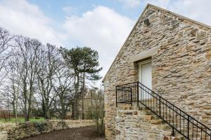 Byers GreenHall Farm Cottage的一座石头建筑,设有窗户旁边的楼梯