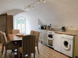Turriff赛慕碧斯特乡村别墅的厨房配有桌椅、炉灶和烤箱。