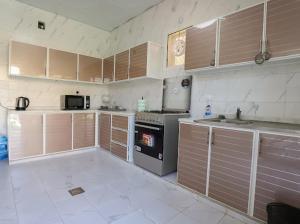 SharīyahRed_Hut_Resort的厨房配有木制橱柜和炉灶烤箱。