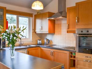 阿德芬Tigh A Vullin - S4628的厨房配有木制橱柜和花瓶。